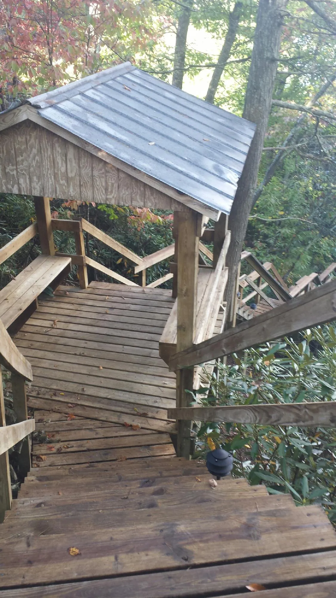 Metal roofed shelter over wooden steps on a wooded walkway — Skylight Repair & Installation work by our crew in Altavista