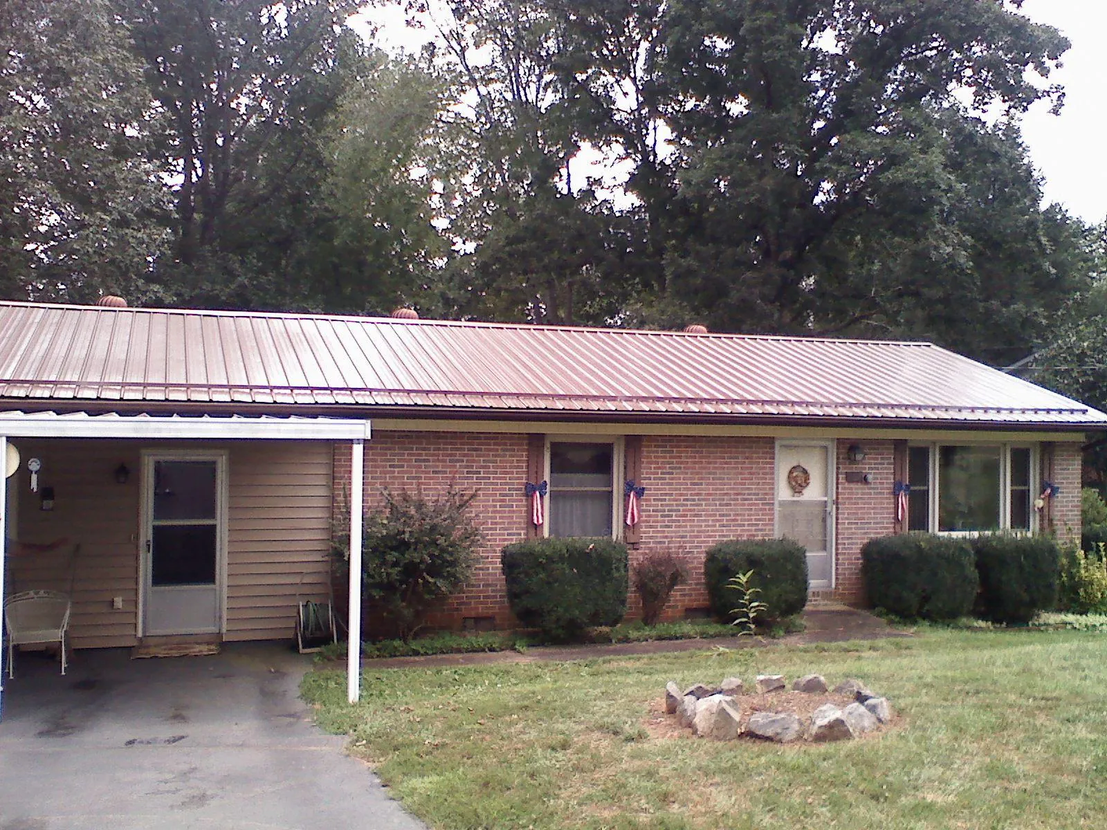 Bronze metal roof and carport on a brick ranch home — Roof Repair work by our crew in Altavista